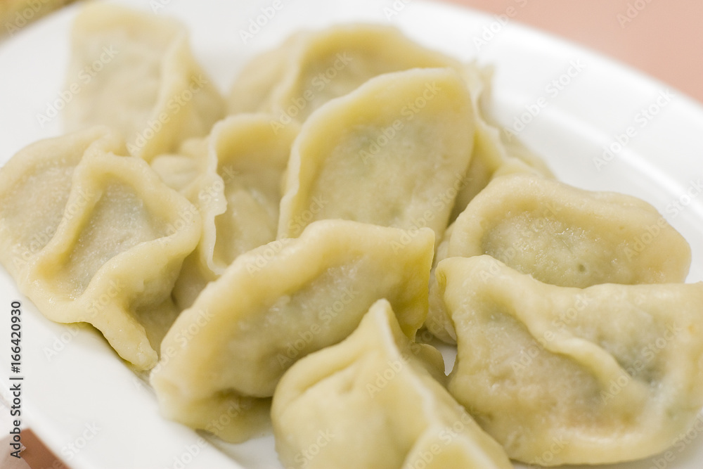 Chinese boiled jiaozi dumplings on a white plate