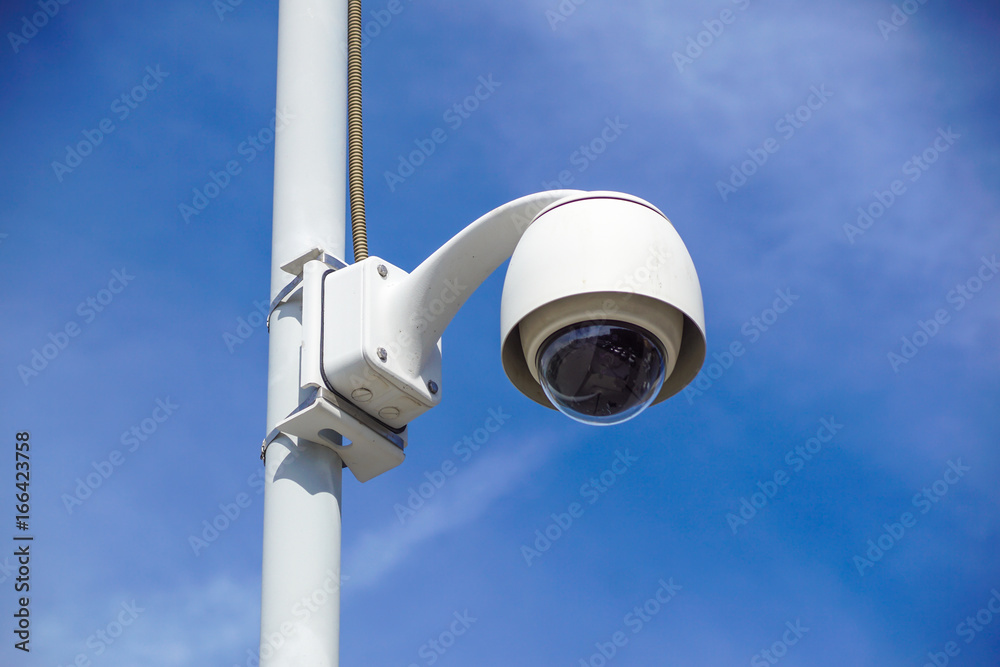 High tech overhead security camera with a gradient blue sky. High tech overhead security camera with a gradient blue sky.