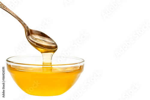 Fresh honey dripping from a spoon. On a white background.