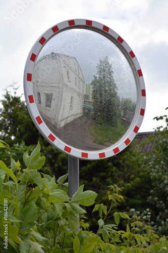 Dewy wet circle street mirror in city