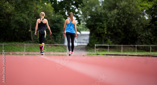 Rückenansicht: Junge Frauen machen beim Lauftraining eine Pause © grafikwerk21