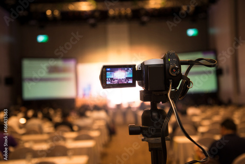 video camera in business conference room recording participants and speaker