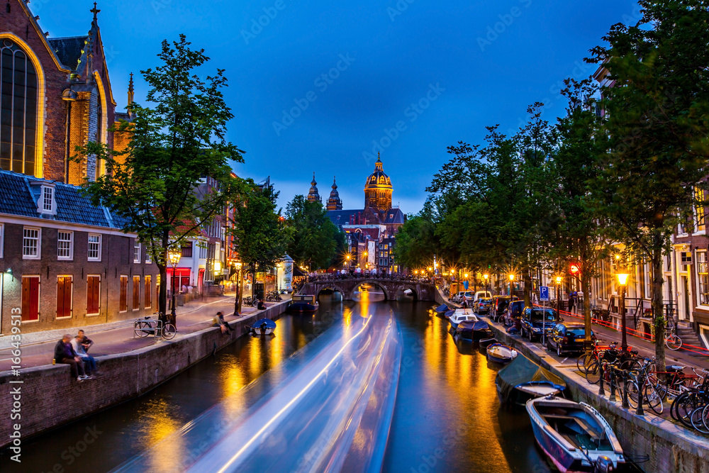 Light streak along canal through bridge, in front of Amsterdam castle
