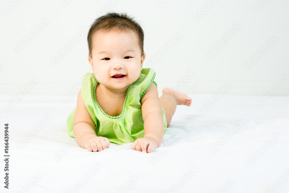 Portrait of adorable infant baby girl with saliva lying on the tummy on bed Portrait of adorable infant baby girl with saliva lying on the tummy on bed
