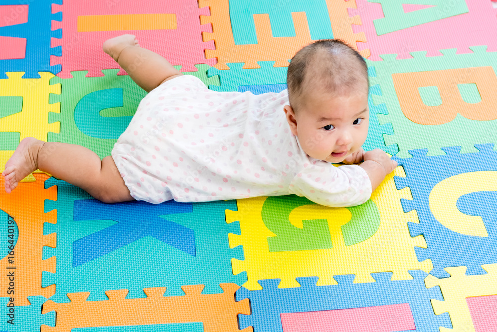 Φωτογραφία Portrait of a little adorable infant baby girl lying on the tummy on colorful ev