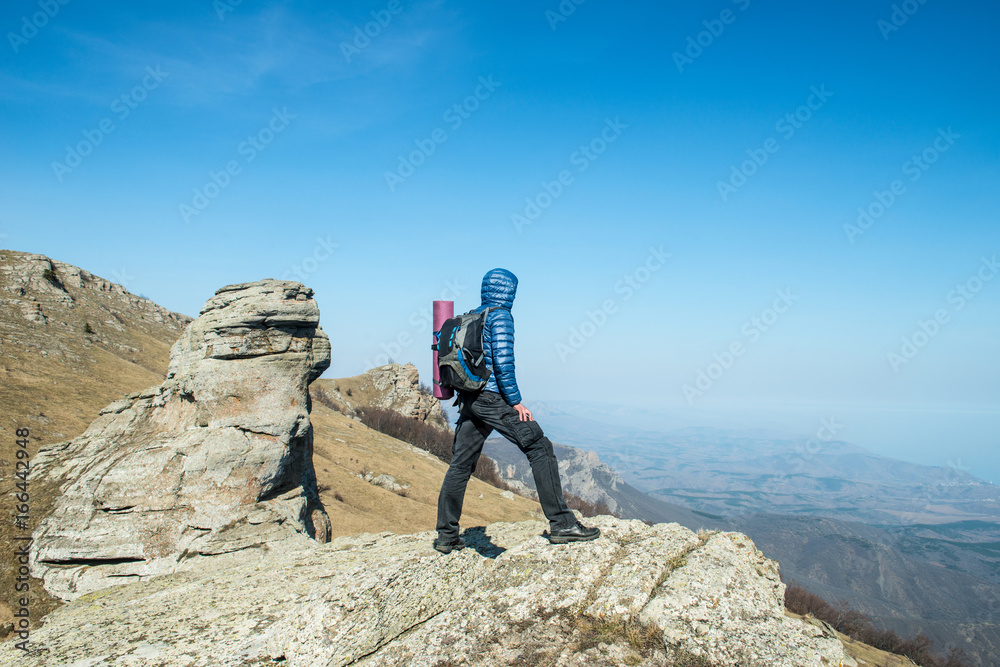 Traveler with backpack on the top of the mountain
