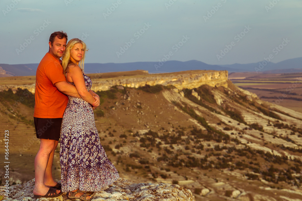 Loving couple on a rock top.