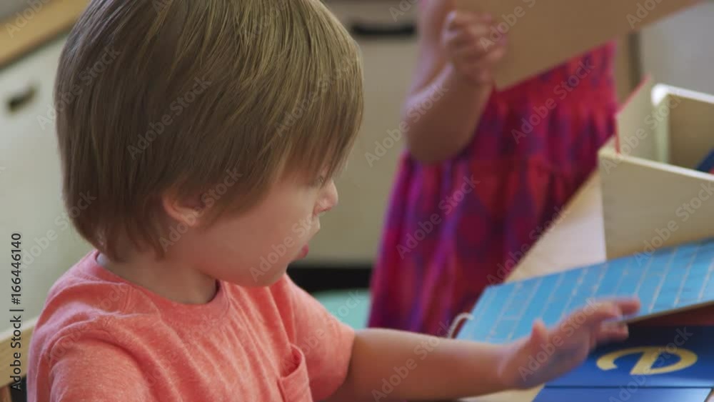Montessori Pupil Working At Desk With Letters On Wooden Shapes
