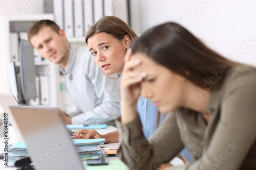 Sad workers looking at a frustrated colleague
