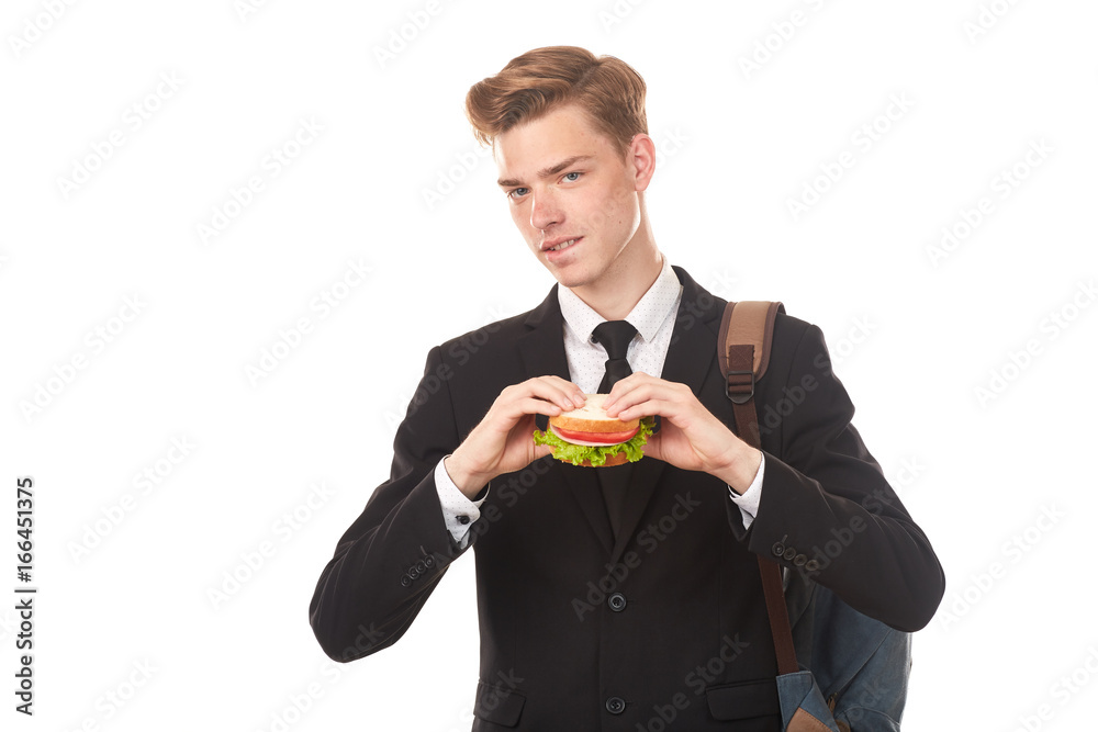 Portrait of college student in black suit eating sandwich against white background Portrait of college student in black suit eating sandwich against white background