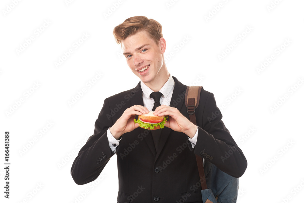Portrait of college student in black suit eating sandwich against white background Portrait of college student in black suit eating sandwich against white background