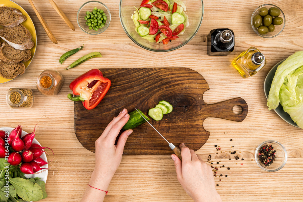 woman cutting cucumber