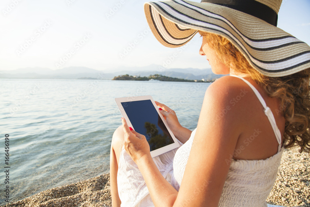 Girl with digital tablet near beach