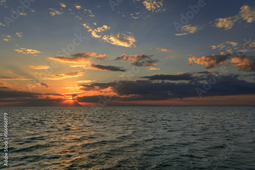 Kitesurfers ride on the waves at sunset © mizinra