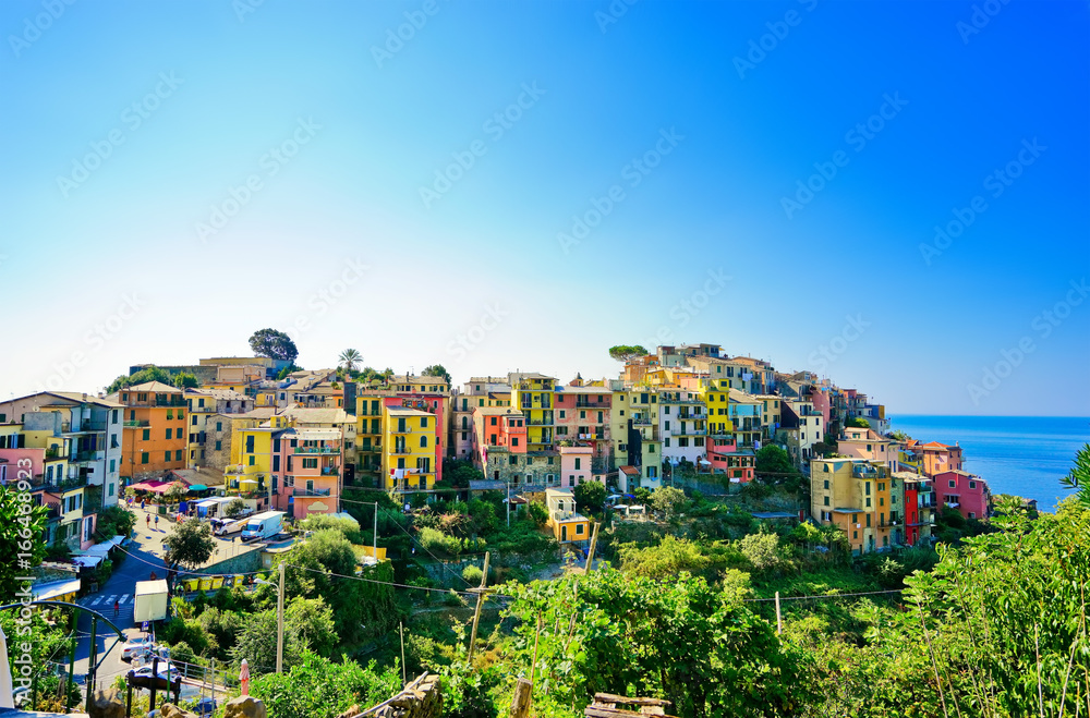 View of the colorful houses along the coastline of Cinque Terre area on a sunny day in Corniglia, Italy.