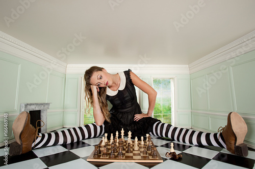 Young woman in small room with chess set
