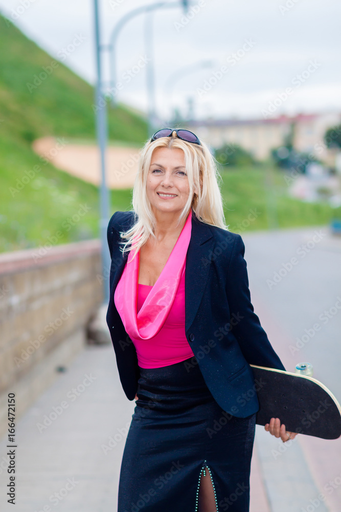 Senior business woman having fun on a skateboard outdoors. The concept of moving forward. Senior business woman having fun on a skateboard outdoors. The concept of moving forward.