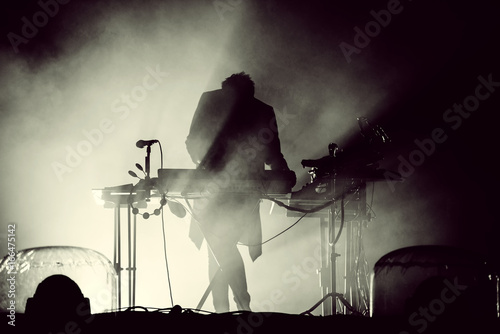 Silhouette of a keyboardist in stage lights