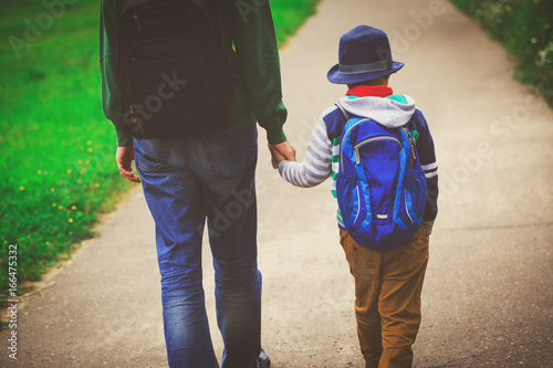 father holding hand of son going to school or daycare