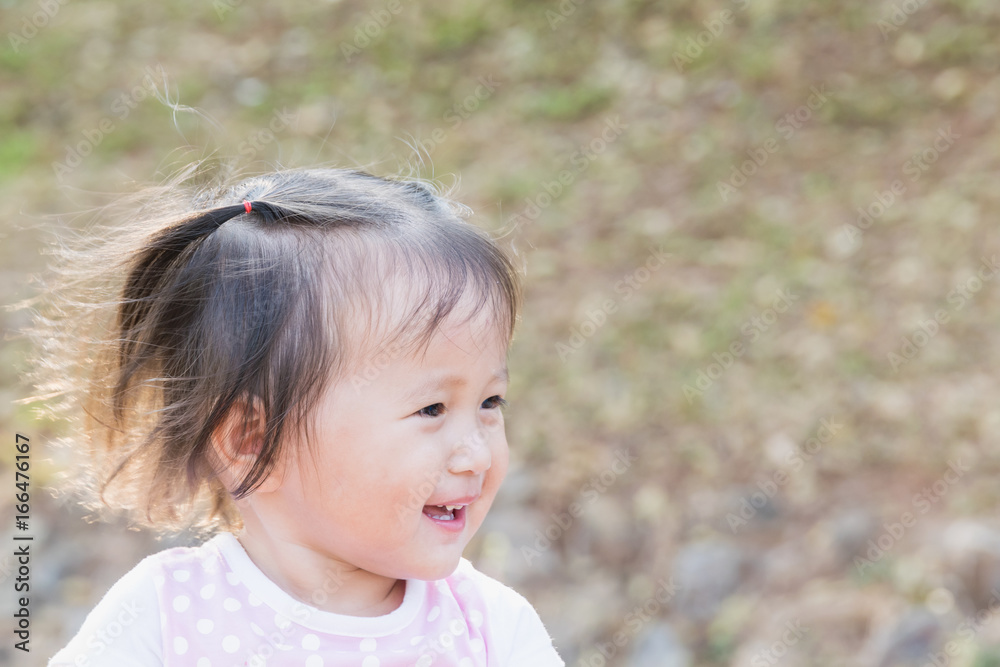 Little Girl Smile : happily smiling girl walks in the park with her family sunset time Little Girl Smile : happily smiling girl walks in the park with her family sunset time