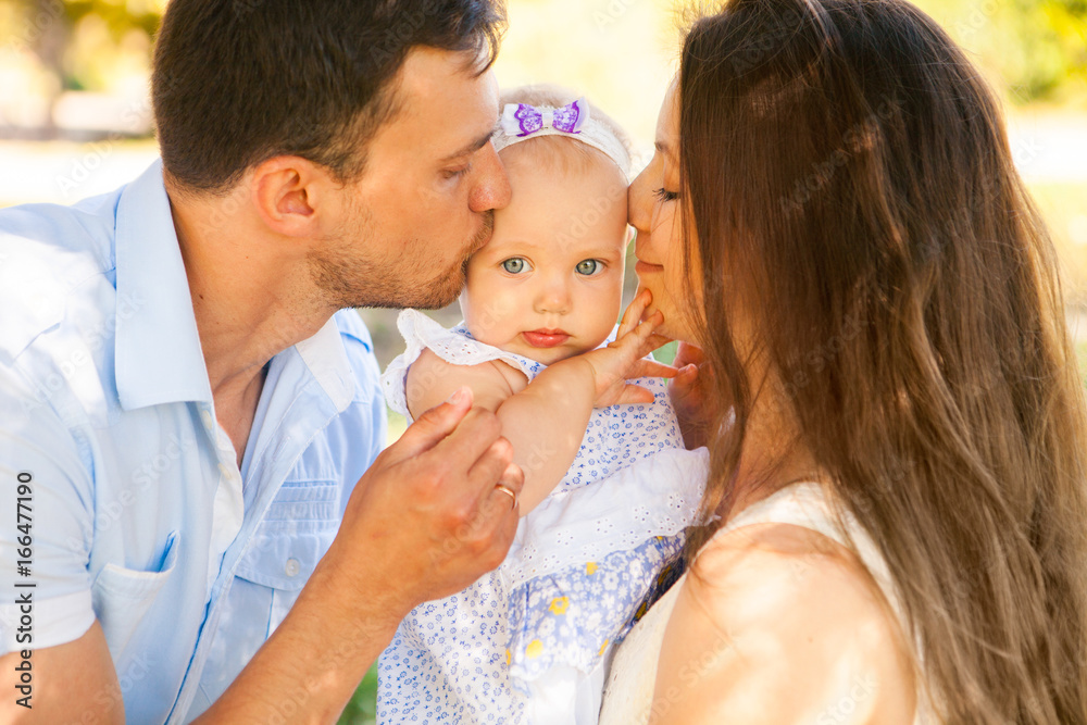 Happy young family spending time outdoor on a summer day, picnic in the park. Happy young family spending time outdoor on a summer day, picnic in the park.