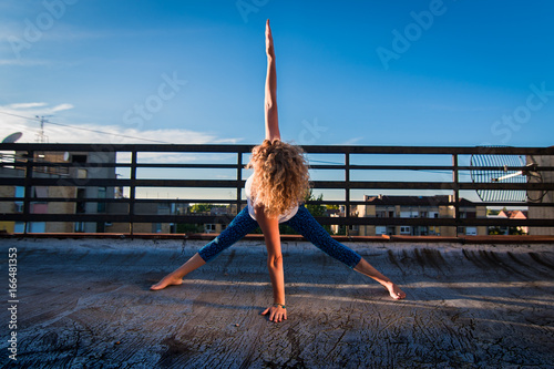 Fotografie Urban yoga - power pose with a waist twist, physically fit mature woman practici