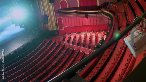 Slider movement through a lighting trust of the first amphitheater with stalls in the background