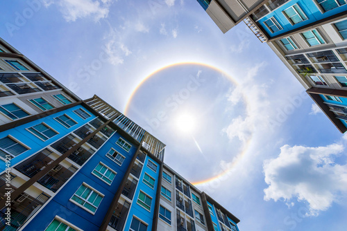 building and sun corona rainbow clouds and blue sky background , Circumscribed halo