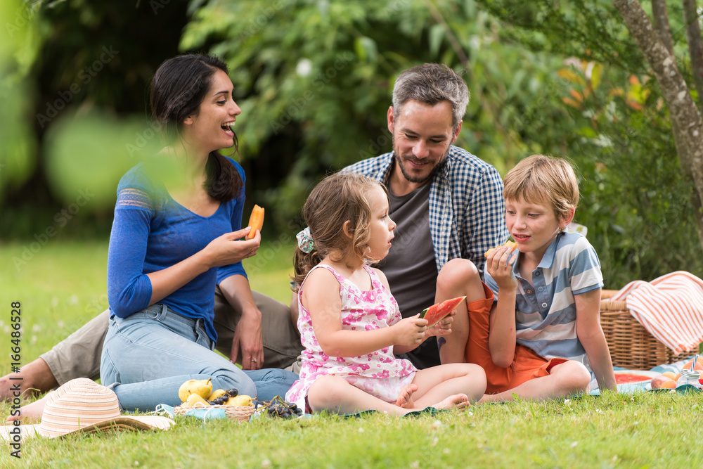 Cheerful family sitting on the grass during un picnic in a park Cheerful family sitting on the grass during un picnic in a park
