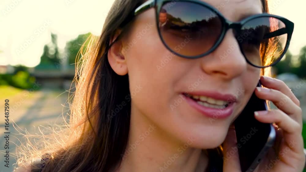 6 in 1 video. Woman in sunglasses using a smartphone outdoors at sunset 6 in 1 video. Woman in sunglasses using a smartphone outdoors at sunset