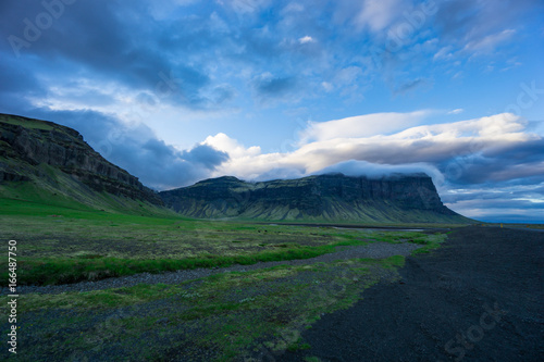 Fototapeta Naklejka Na Ścianę i Meble -  Iceland - Clouds hanging over green volcanic mountains at dawn