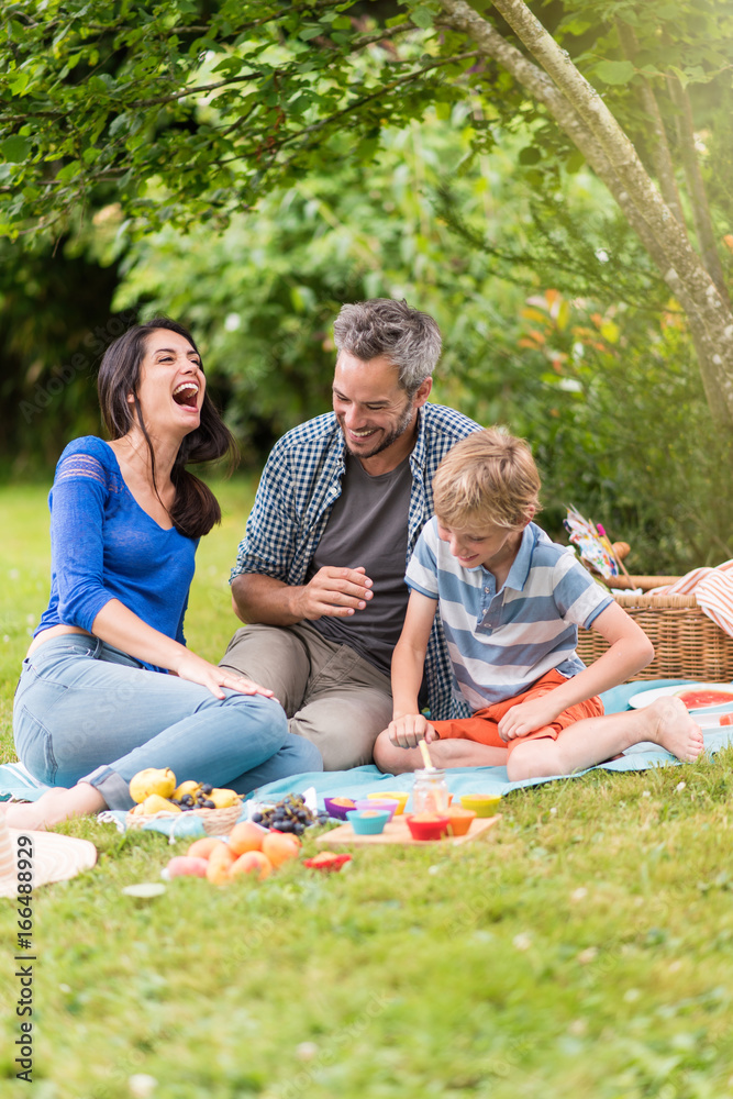 Cheerful family sitting on the grass during un picnic in a park Cheerful family sitting on the grass during un picnic in a park