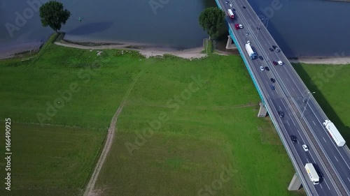 Aerial: highway traffic on bridge by river Lek near Vianen in the Netherlands, flying over the river – 4K photo