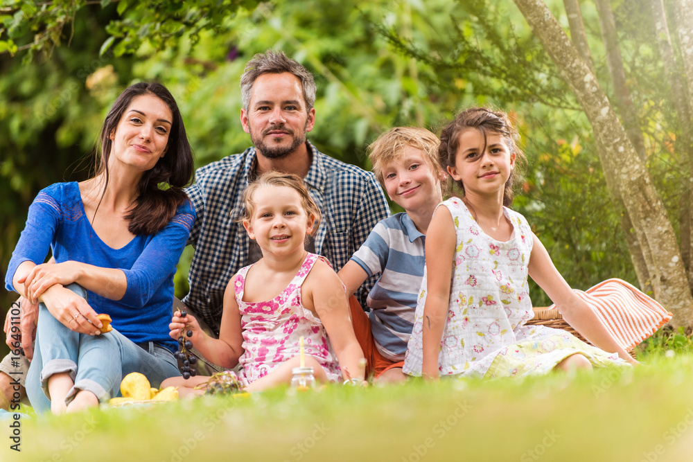 Cheerful family sitting on the grass during un picnic in a park Cheerful family sitting on the grass during un picnic in a park