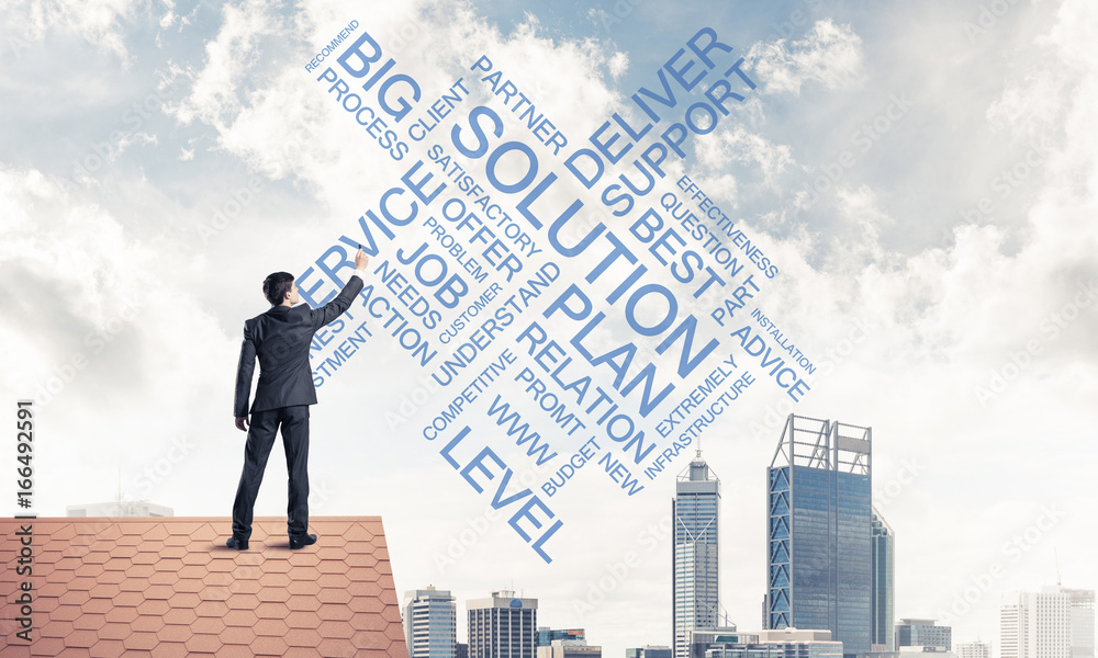 Young businessman standing on house roof and writing leadership Young businessman standing on house roof and writing leadership