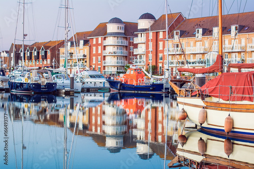 Yachts and houses in Sovereign harbour in Eastbourne, reflection in the water, selective focus, England, United Kingdom