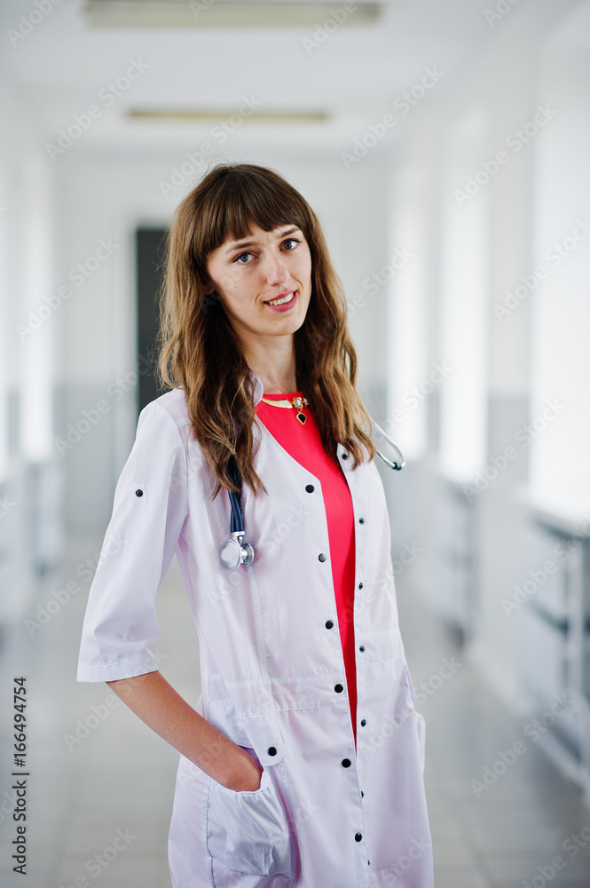 Portrait of a young attractive doctor in white coat with stethoscope posing in the hospital. Portrait of a young attractive doctor in white coat with stethoscope posing in the hospital.