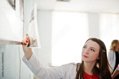 Portrait of a doctor looking at x-ray image of her patient's body part.