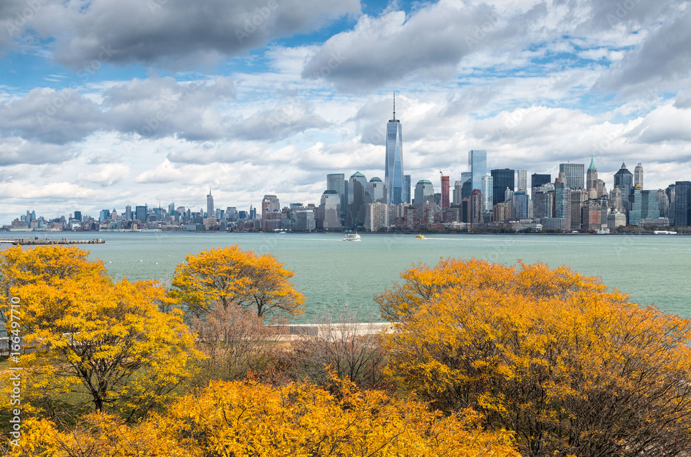 View of Downtown Manhattan from Ellis Island with autumnal trees