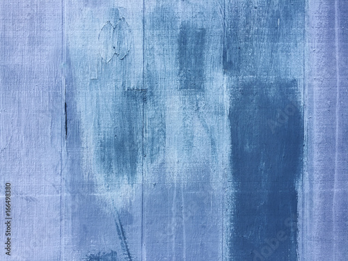 Blue and purple paint covering graffiti tags on building wall, close up