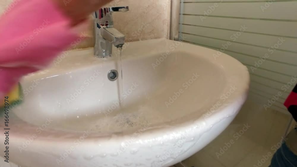 a Woman in Gloves Washes the Sink in the Bathroom 2 a Woman in Gloves Washes the Sink in the Bathroom 2