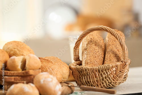 Basket with delicious bread on blurred background