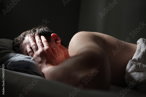 Young Man Sleeping With Hand Covering His Face photo