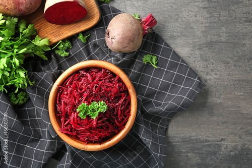 Bowl of fresh grated beet on table
