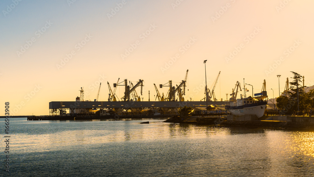 Transportation and logistic. Freight cargo cranes in seaport on sunset