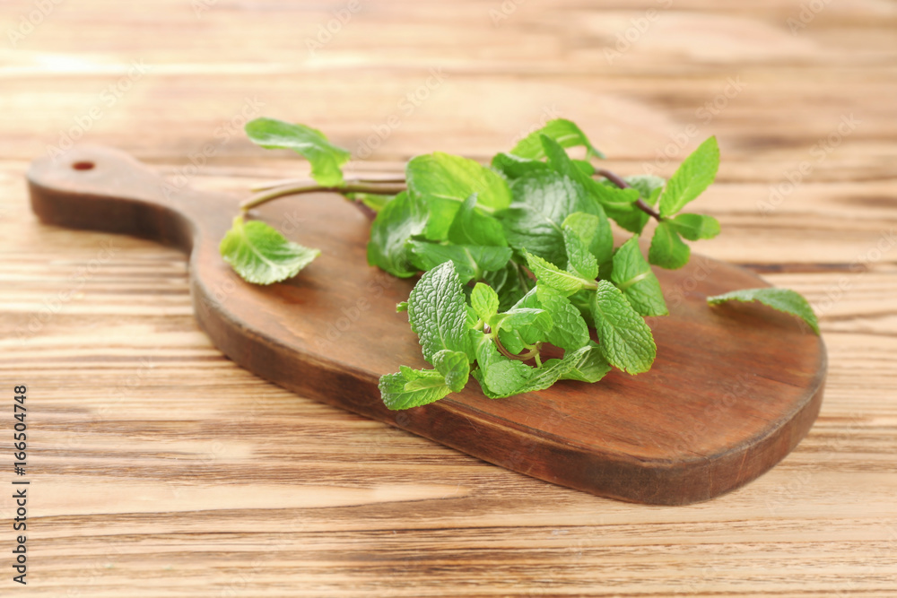 Wooden board with lemon balm on table Wooden board with lemon balm on table
