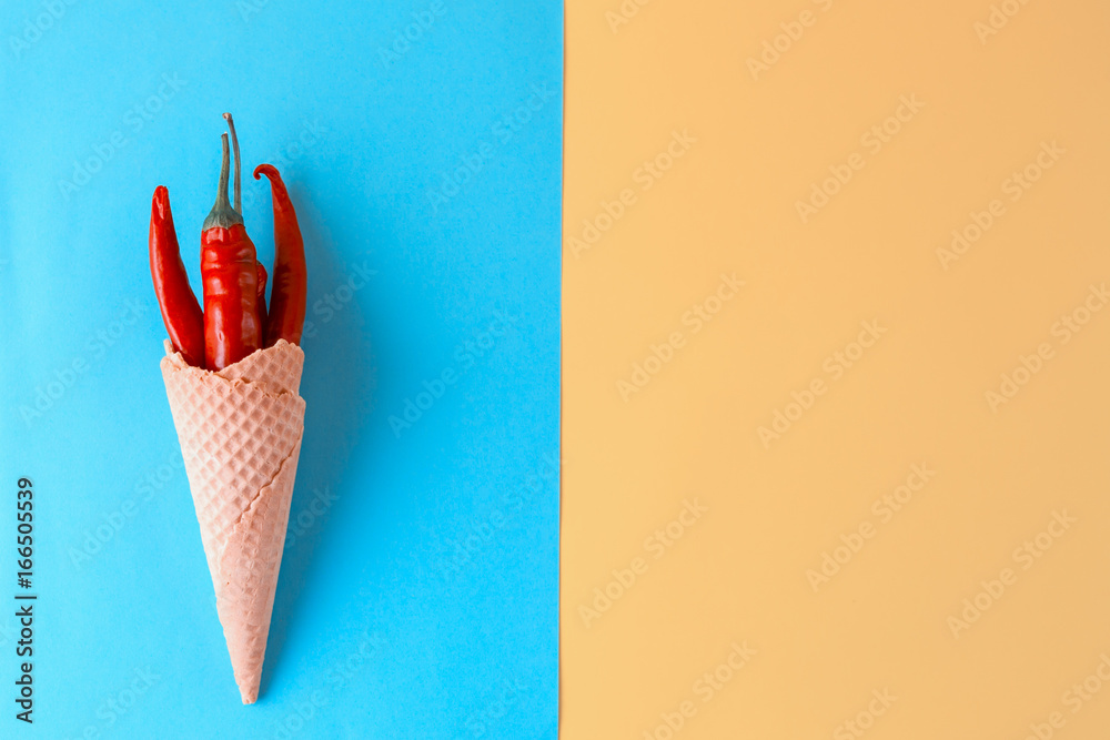 Unusual ice cream. Red hot chili peppers in a wafer cone - obrazy, fototapety, plakaty 