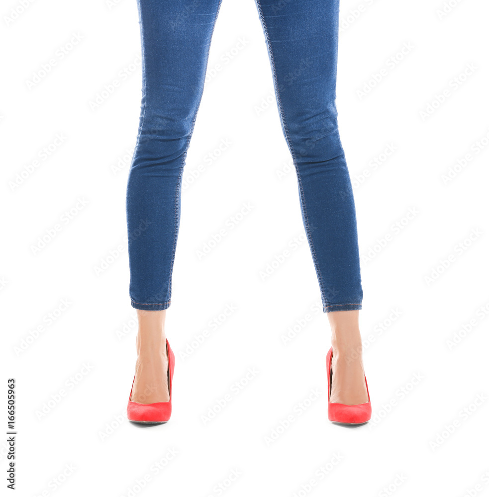 Slim female legs in high heels and jeans on white background Slim female legs in high heels and jeans on white background