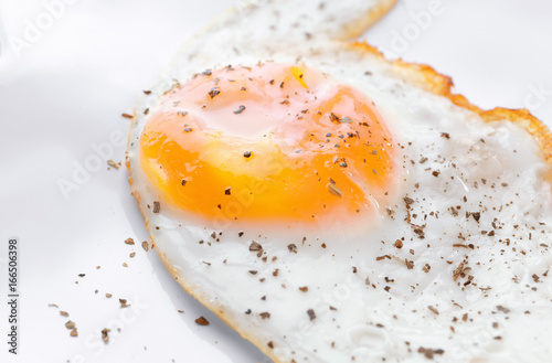 Closeup view of over hard fried egg on white plate