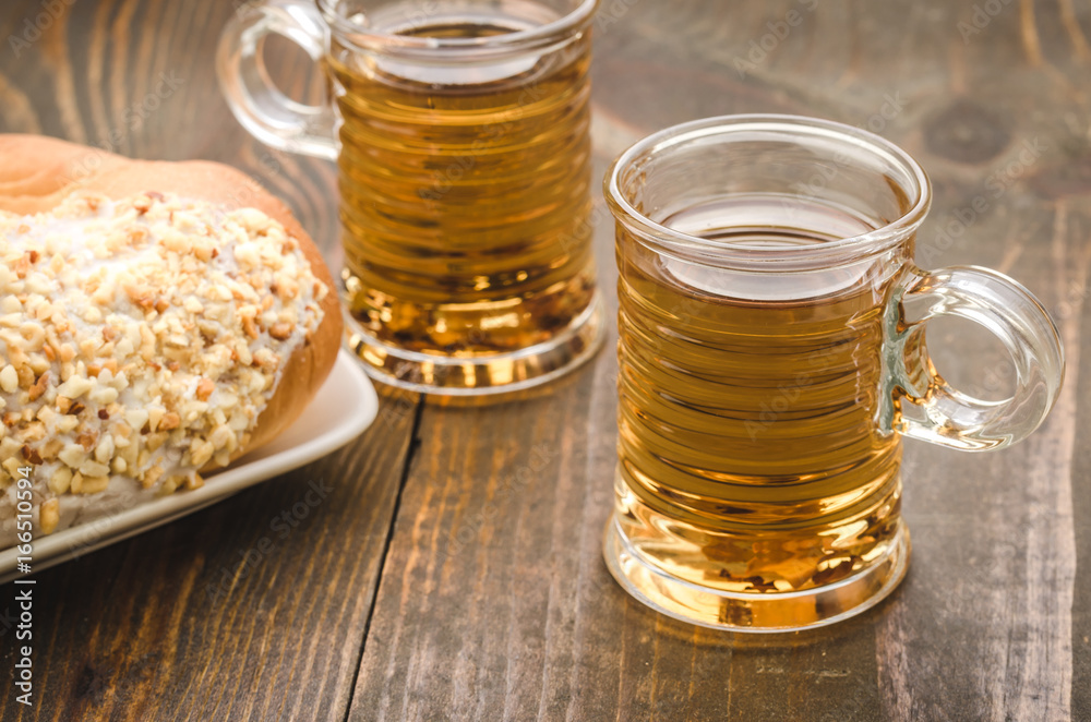 two glasses with tea and croissant/two glasses with tea and croissant on a wooden background